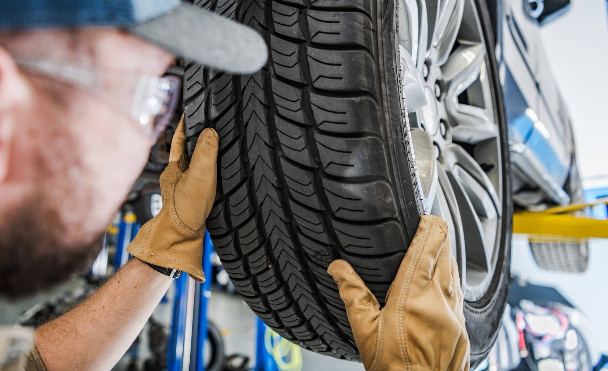 Inspection détaillée d'un pneu de voiture suspendu.
